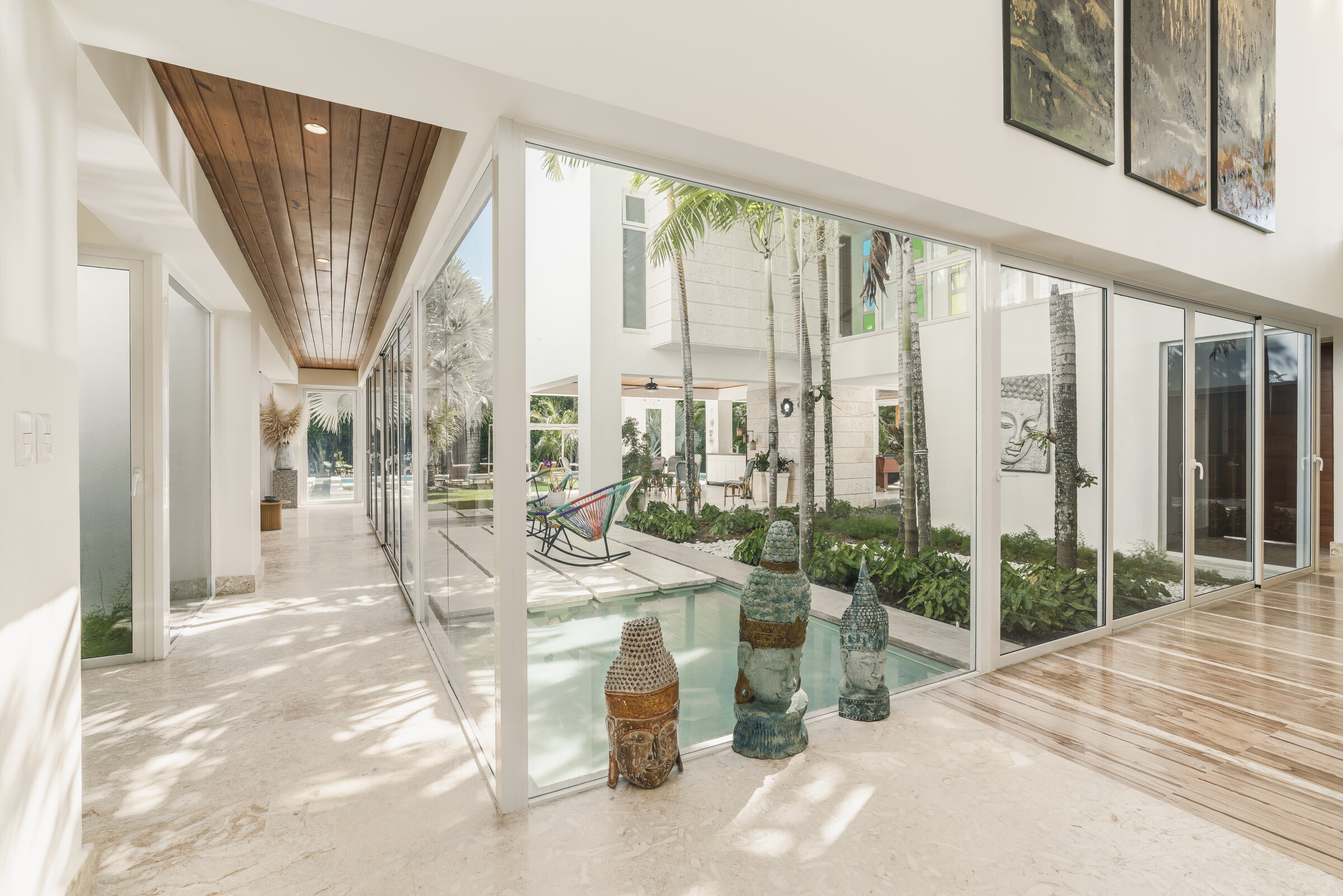 Corredor interior Villa Eden — patio central con estatuas y jardín tropical