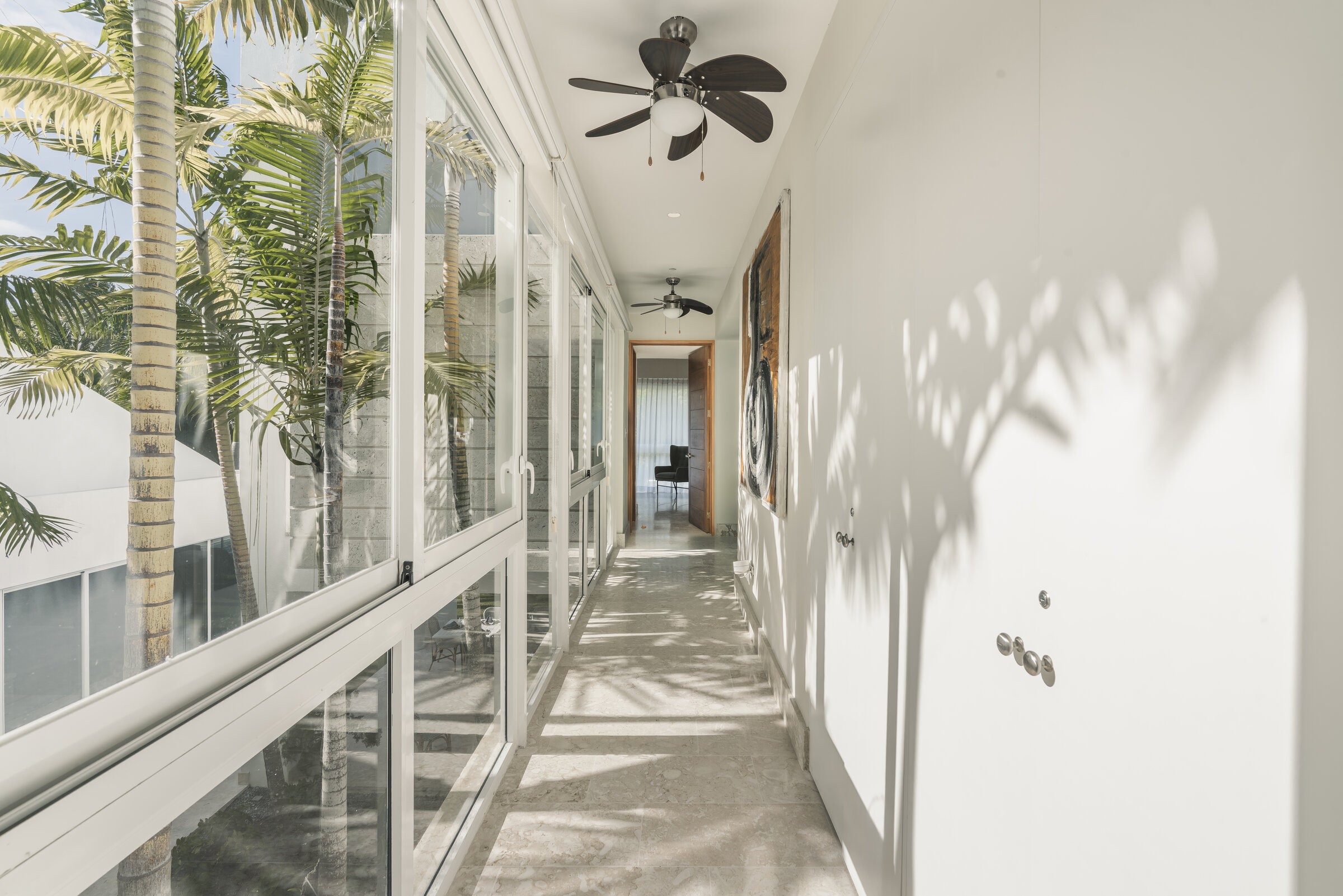 Pasillo interior Villa Eden — ventanas panorámicas al patio central