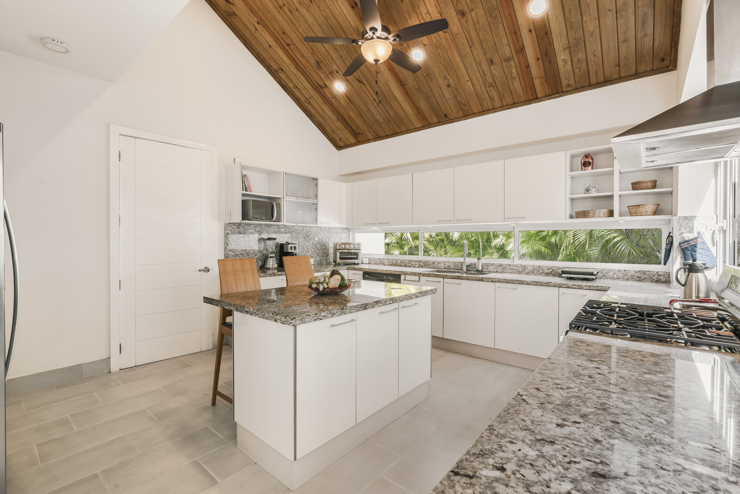 Cocina gourmet Villa Eden — isla de granito y techo de madera tropical