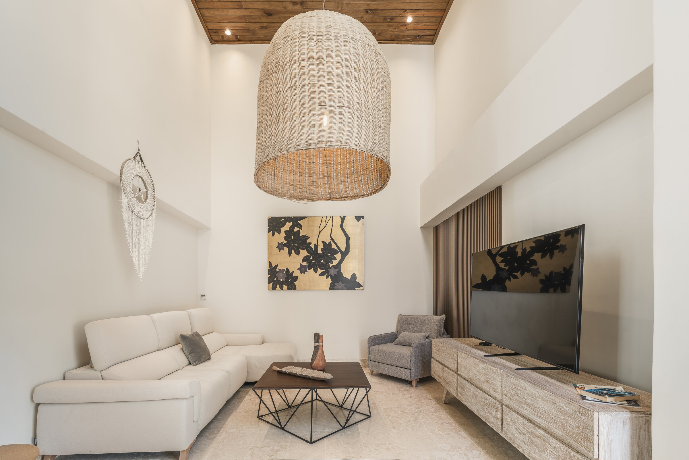 Sala de estar Villa Eden — sala TV con lámpara rattan y techo de madera