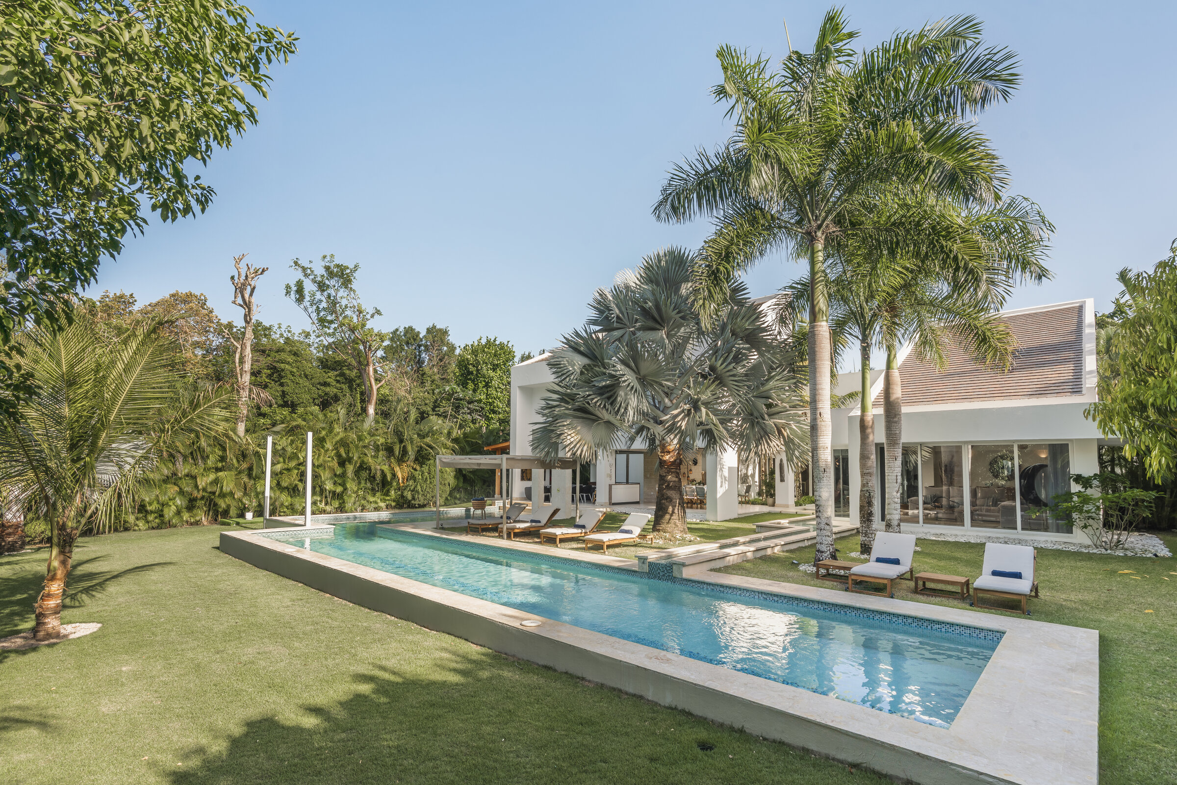 Piscina de lujo Villa Eden Punta Cana — rodeada de palmeras y jardines
