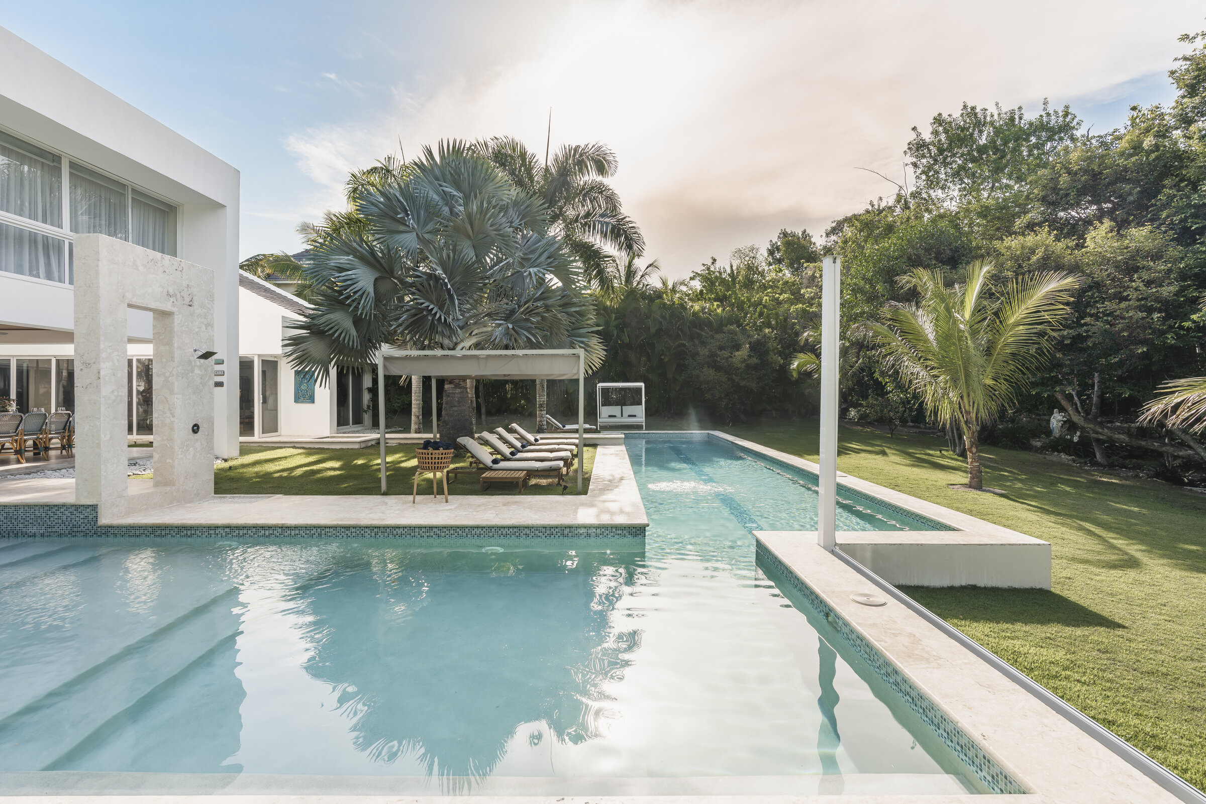 Piscina olímpica Villa Eden — sillas reclinables y zona lounge