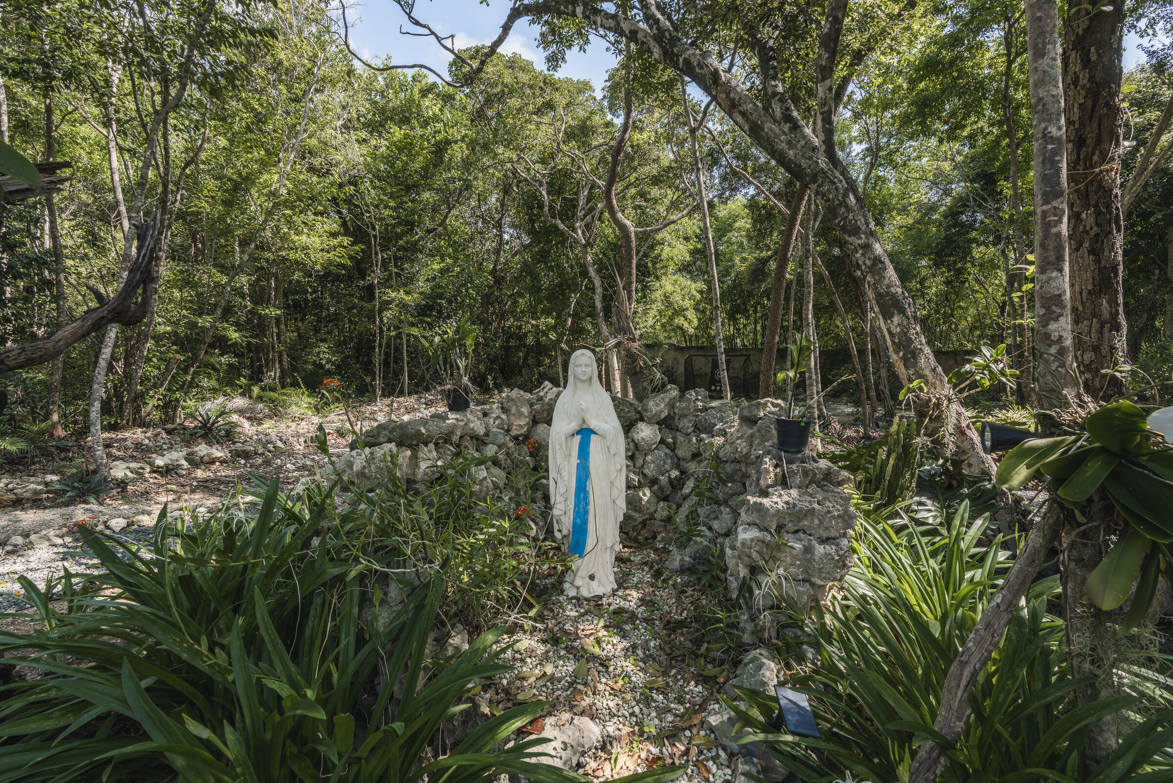 Jardín bosque Villa Eden — gruta con Virgen María en naturaleza tropical