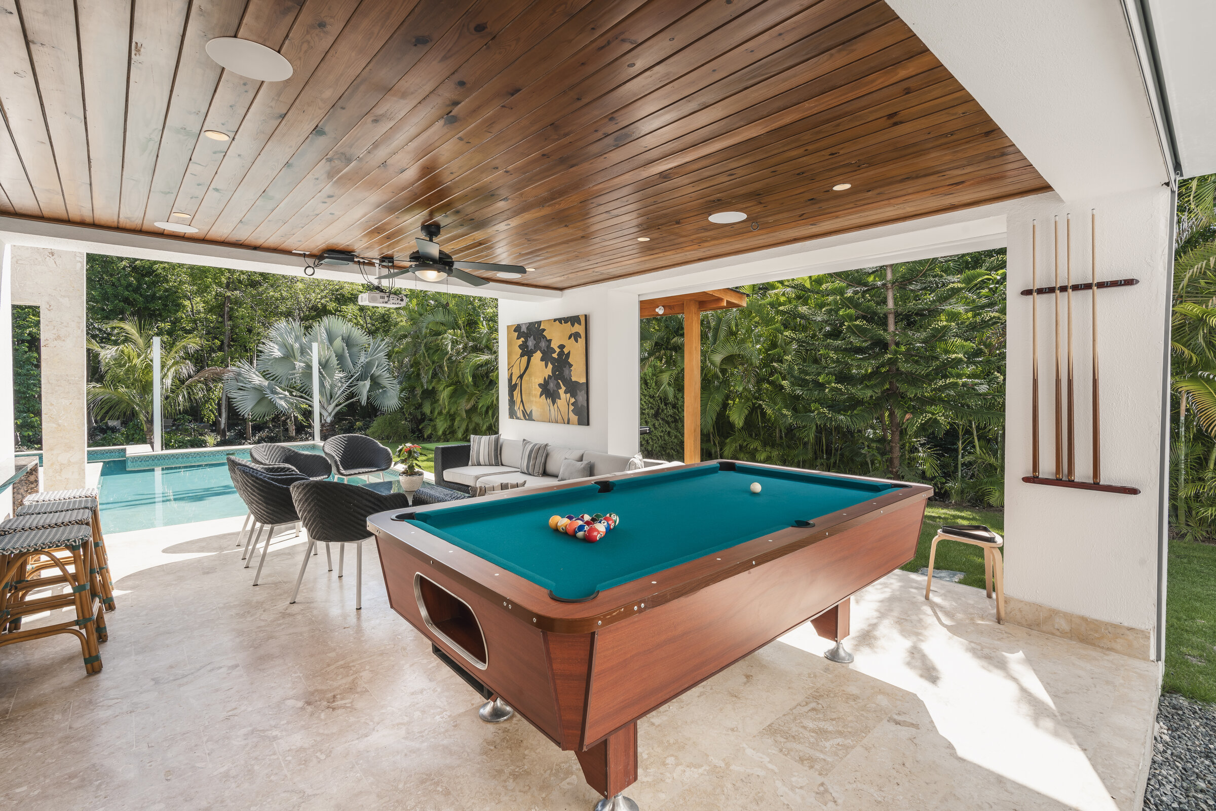 Sala de juegos Villa Eden — mesa de billar bajo techo con vista a la piscina