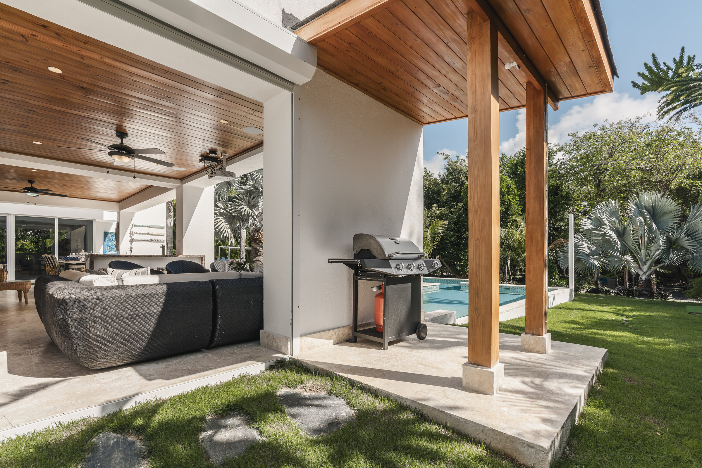 Zona de parrillero Villa Eden — BBQ cubierto junto a la piscina y jardín tropical