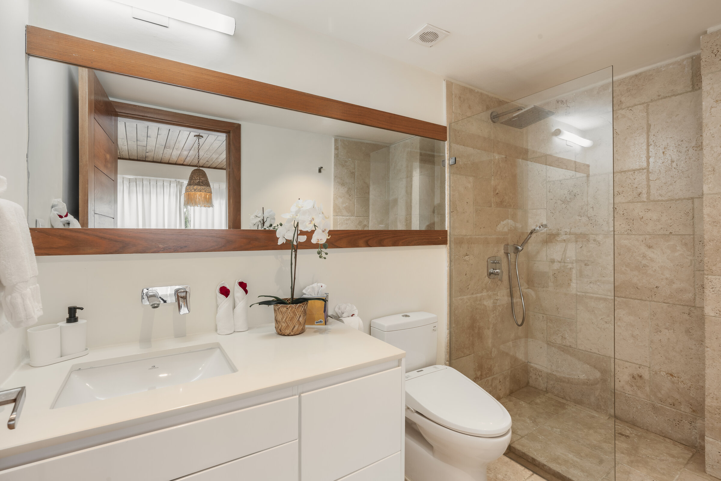 Baño Villa Eden — ducha de cristal y tocador de mármol con acabados en madera