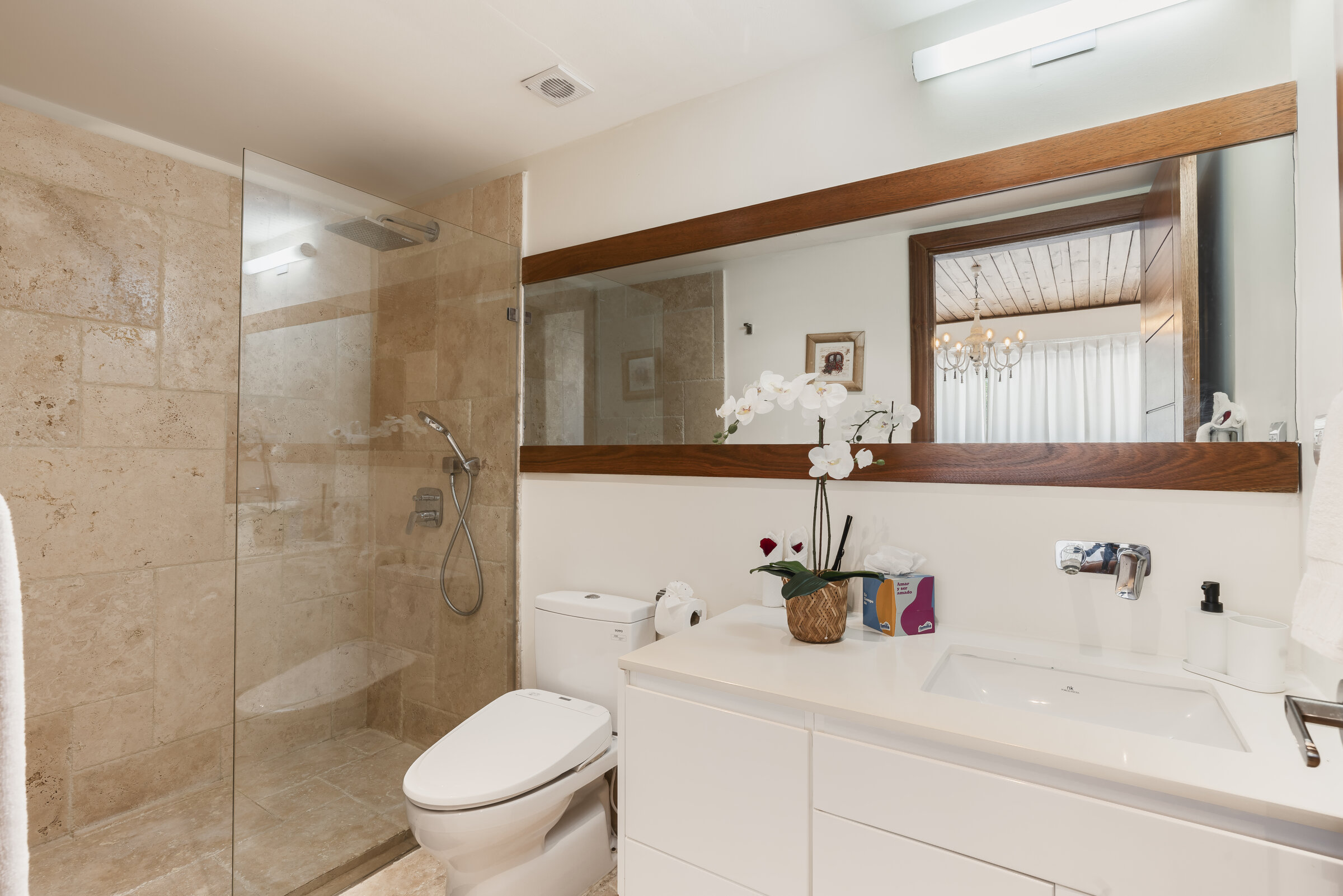 Baño en suite Villa Eden — ducha de vidrio y espejo con marco de madera