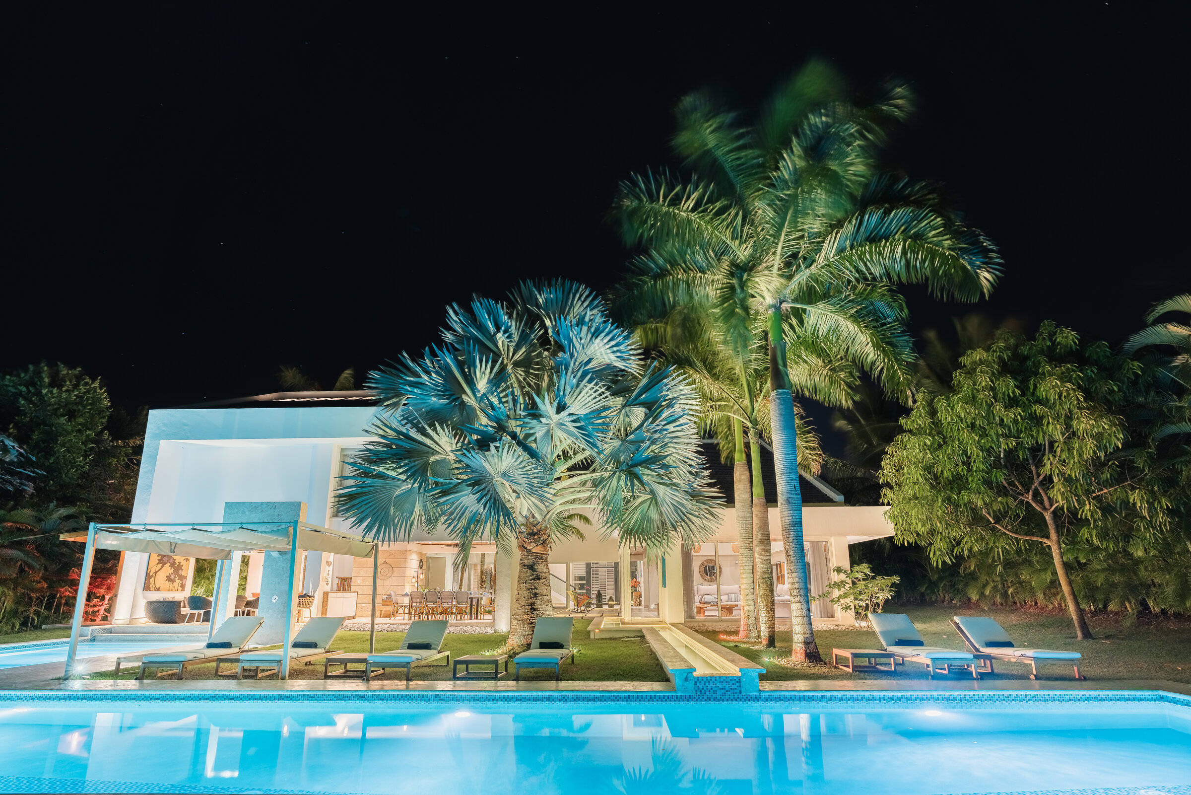 Villa Eden de noche — fachada iluminada con piscina y palmeras