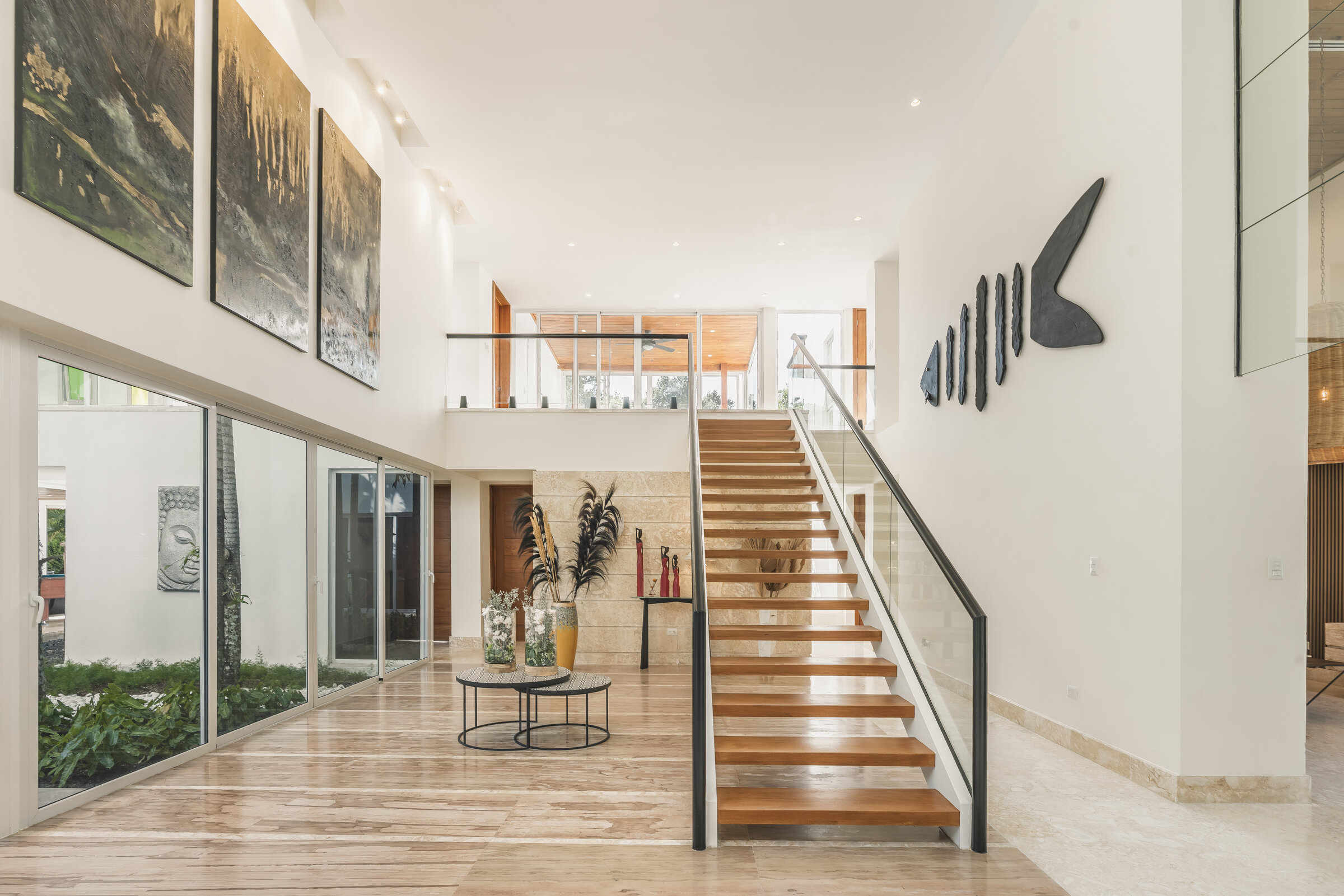 Interior sala Villa Eden — diseño moderno con escaleras de vidrio