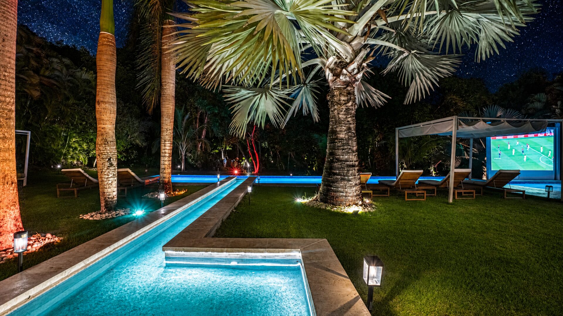 Cine exterior junto a la piscina Villa Eden — pantalla y ambiente nocturno